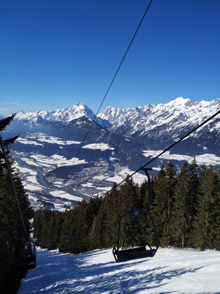 Sessellift eines Skigebiets mit Blick über das verschneite Inntal und die Berge rund um Rum in Tirol