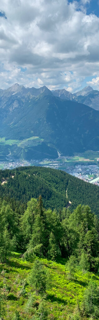 Panoramablick über bewaldete Hänge auf das Inntal mit Ortschaften und Alpengipfeln bei Wattens in Tirol