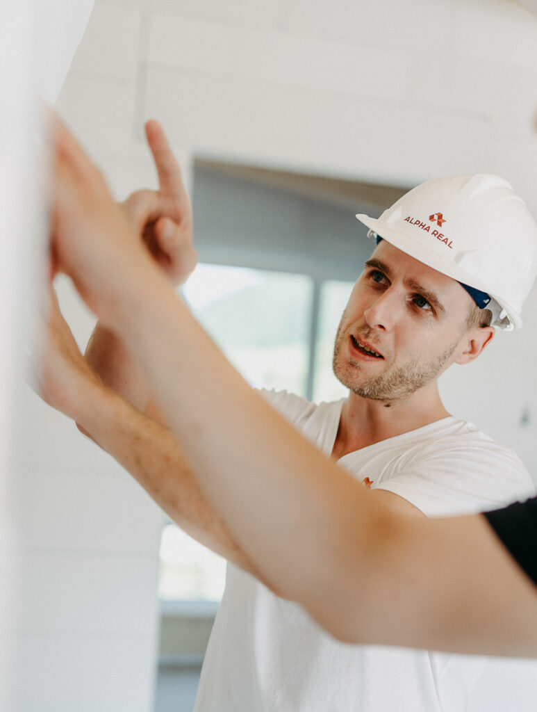 alphareal berater auf einer baustelle mit bauplan